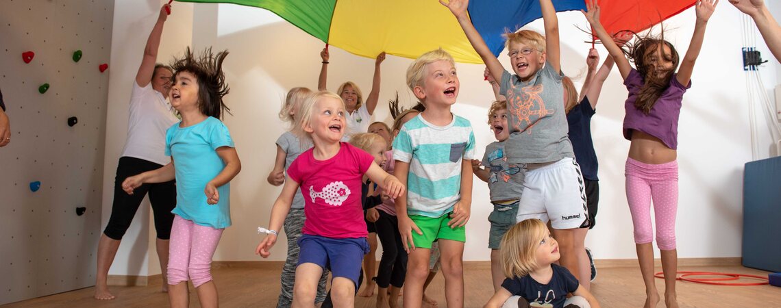 Kinder jubeln unter dem bunten Schwungtuch